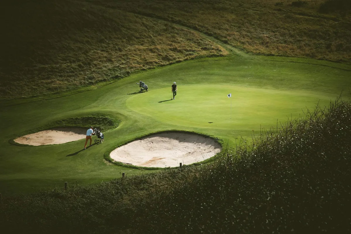 A well-maintained parkland golf course near Manchester with mature trees lining the fairway