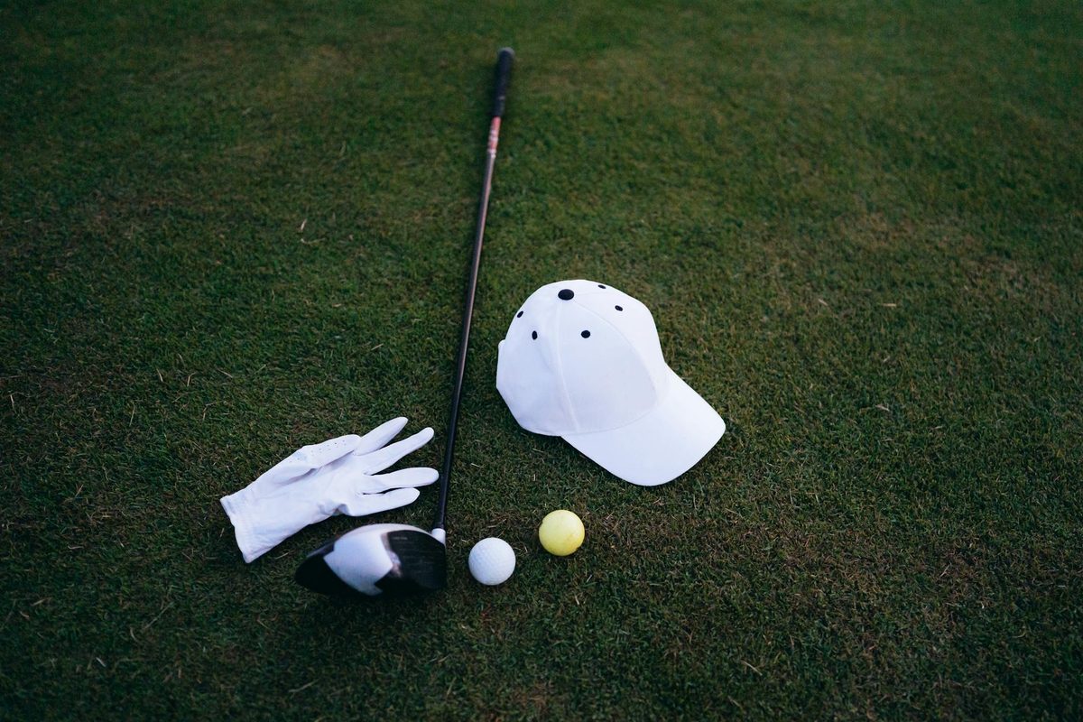 A collection of small golf accessories including tees, ball markers, and a divot tool on a green