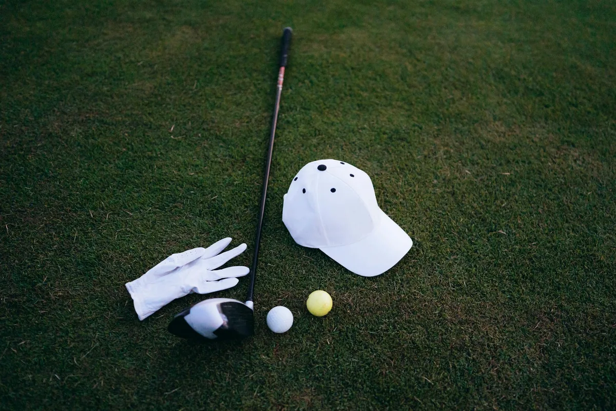 A collection of small golf accessories including tees, ball markers, and a divot tool on a green
