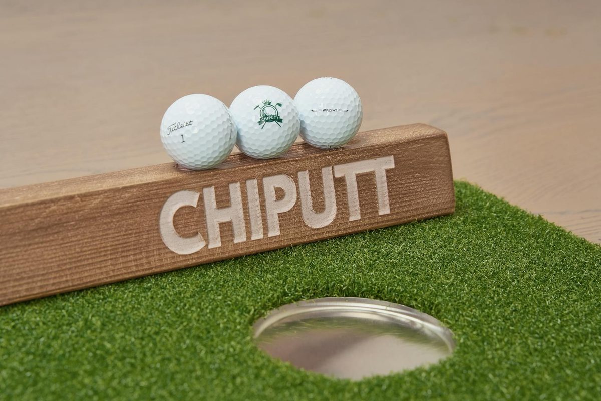 A collection of premium golf accessories and equipment laid out as gift ideas