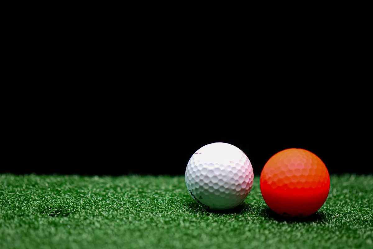 An assortment of golf ball types arranged on a wooden surface showing different options