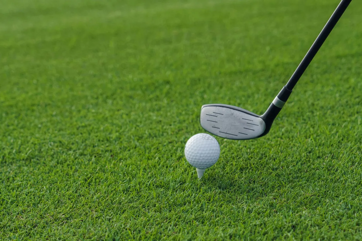 A golfer demonstrating a correct swing path to eliminate a slice on the driving range