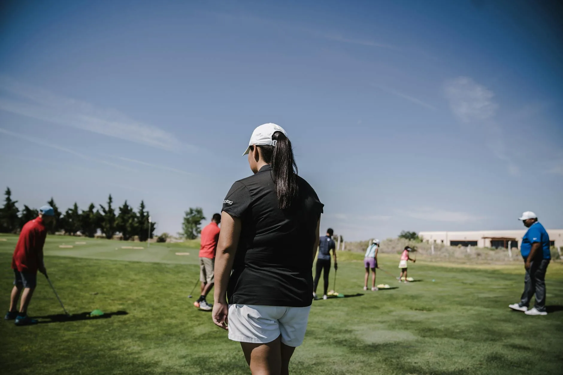 A golfer lining up a putt on a well-maintained green on a bright day