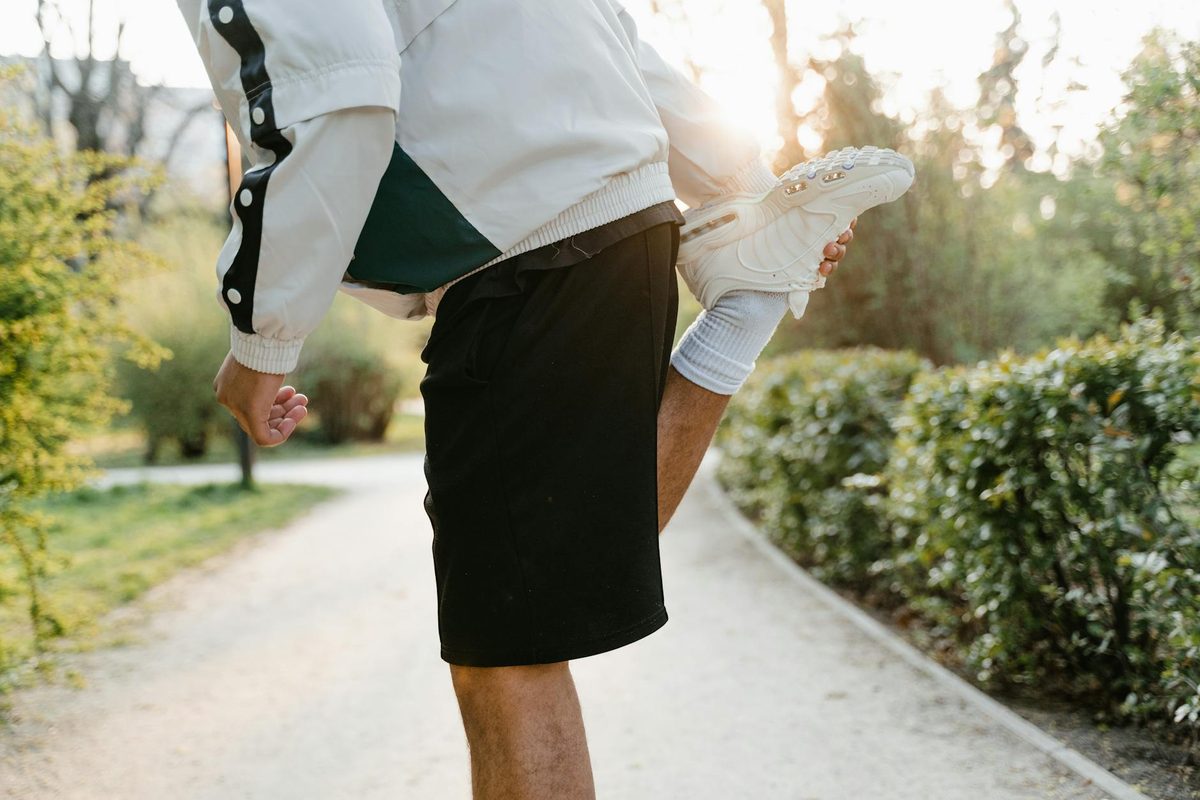 A golfer stretching on the tee box before a round on a sunny morning