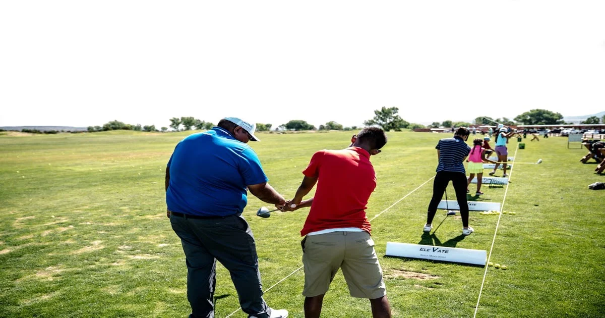 PGA golf instructor coaching a beginner on a driving range